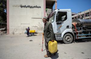 <p>Palestinian man Ali Oroq, whose grandson Zein was wounded after he was hit by aid airdropped on Gaza and later succumbed to his wounds, carries a water container as he walks at a school sheltering displaced people, amid the ongoing conflict between Israel and the Palestinian Islamist group Hamas, in Gaza City April 16, 2024. REUTERS/Dawoud Abu Alkas</p>