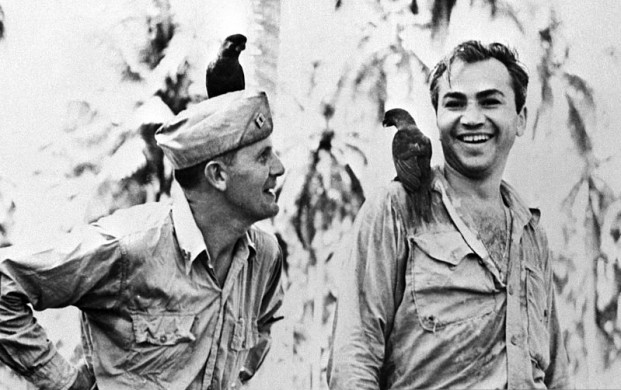 <p>(Original Caption) 3/13/1943-Guadalcanal-Corporal Barney Ross of the United Staes Marine Corps is shown in this photo with Father Frederick Gehring,Catholic Chaplain on Guadalcanal,as they made friends with two "Peace Birds"who alighted on them on Island of "Kill or be Killed." Ross has paid a remarkable tribute to Father Gehring,who is a former teacher at St. John's Prep School in Brooklyn.Over his heart Ross wears a little Catholic medal next to his own Jewish Mezuzeh. The medal was given him by Father Gehring.</p>