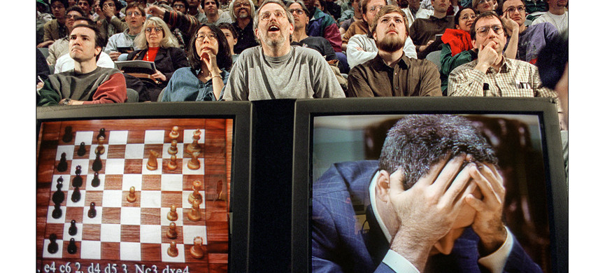 NEW YORK, UNITED STATES: Chess enthusiasts watch World Chess champion Garry Kasparov on a television monitor as he holds his head in his hands at the start of the sixth and final match 11 May 1997 against IBM's Deep Blue computer in New York. Kasparov lost this match in just 19 moves giving overall victory to Deep Blue with a score of 2.5-3.5. AFP PHOTO Stan HONDA (Photo credit should read STAN HONDA/AFP/Getty Images)