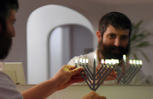 <p>Yitzy Kasowitz places one his Lego Menorahs on the fireplace mantel at his Highland Park home in St. Paul on Wednesday, Dec. 2, 2015. Kasowitz's business, JBlock, produces Jewish-themed Lego sets. (Pioneer Press: John Autey)</p>