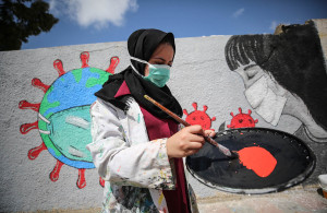 <p>Palestinian painters work on a mural to draw attention to the novel coronavirus pandemic in Khan Yunis, Gaza, on March 28. Mustafa Hassona/Anadolu Agency via Getty Images</p>