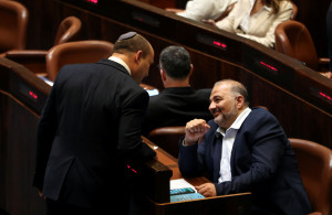 <p>Naftali Bennett, Prime Minister-designate chats with United Arab List party leader Mansour Abbas during a special session of the Knesset, Israel's parliament, whereby a confidence vote will be held to approve and swear-in a new coalition government, in Jerusalem June 13, 2021. REUTERS/Ronen Zvulun</p>