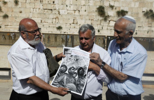 <p>Israeli veterans of the 1967 Arab-Israeli war Zion Karasenti (L), Yitzhak Yifat (C) and Haim Oshri (R) pose with a copy of their 1967 photo at the Western Wall in Jerusalem's Old City on May 11, 2017. The three soldiers where documented 50 years ago at the same place in a picture taken by late Israeli photographer David Rubinger and became one of the most iconic photo of the war after Israel captured the east part of the city. / AFP PHOTO / MENAHEM KAHANA (Photo credit should read MENAHEM KAHANA/AFP via Getty Images)</p>