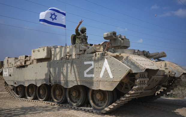 <p>An Israeli soldier flashes a V-sign from an armoured personnel carrier (APC) as they head towards the Gaza Strip border in southern Israel, Saturday, Oct. 14, 2023. (AP Photo/Ariel Schalit)</p>