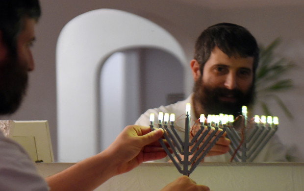 <p>Yitzy Kasowitz places one his Lego Menorahs on the fireplace mantel at his Highland Park home in St. Paul on Wednesday, Dec. 2, 2015. Kasowitz's business, JBlock, produces Jewish-themed Lego sets. (Pioneer Press: John Autey)</p>