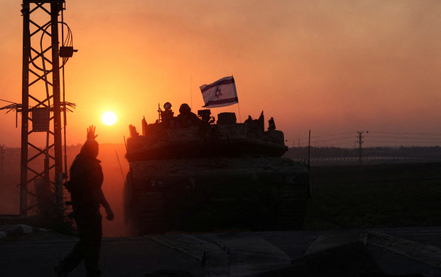 <p>An Israeli soldier looks out from a tank at sunset as an artillery unit gathers near Israel's border with the Gaza Strip, in southern Israel, October 12, 2023. REUTERS/Ronen Zvulun TPX IMAGES OF THE DAY</p>