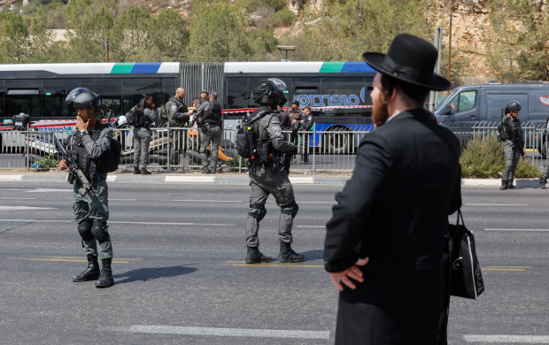 <p>A man stands as Israeli security personnel secure the scene where a suspected shooting attack took place at the outskirts of Jerusalem, September 8, 2025 REUTERS/Ammar Awad</p>