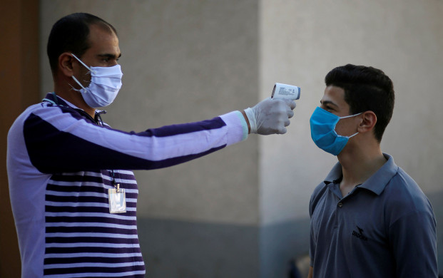 <p>A Palestinian student, wearing a protective face mask, has his body temperature checked as he arrives to take high school exams, amid concerns about the spread of the coronavirus disease (COVID-19), in Gaza City, May 30, 2020. REUTERS/Mohammed Salem</p>