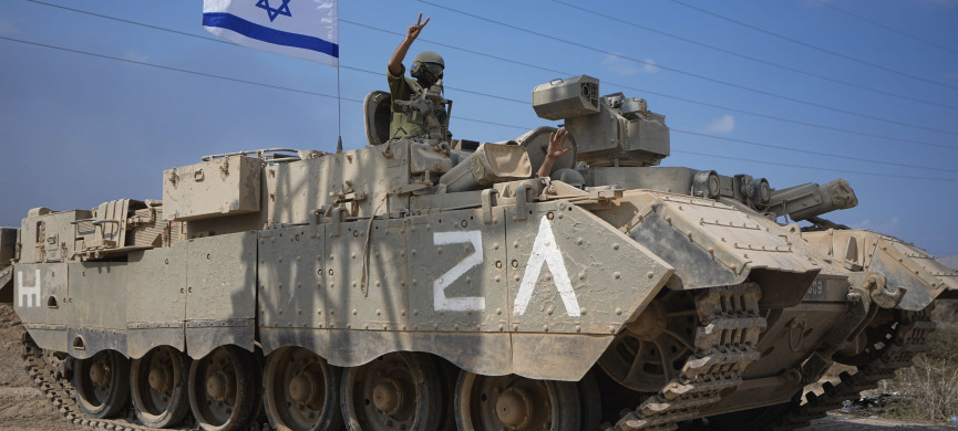 <p>An Israeli soldier flashes a V-sign from an armoured personnel carrier (APC) as they head towards the Gaza Strip border in southern Israel, Saturday, Oct. 14, 2023. (AP Photo/Ariel Schalit)</p>